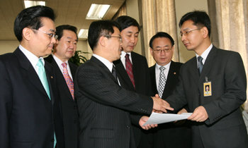 열린우리당 탈당파 의원들이 결성한 ‘중도개혁통합 신당추진모임’의 원내대표를 맡은 최용규 의원(왼쪽에서 세 번째)이 12일 모임 소속 의원들과 함께 국회 의사과 직원에게 원내교섭단체 등록 신청서를 제출하고 있다. 김동주 기자