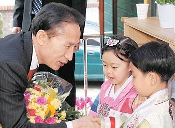 이명박 전 서울시장이 13일 서울 강북구 미아동 구립 어린이집을 방문해 어린이들로부터 꽃다발을 받고 있다. 이 전 시장은 이 자리에서 보육 관계자들을 만나 ‘국가 의무 보육 시스템-보육정책 5대 비전’을 밝혔다. 홍진환  기자