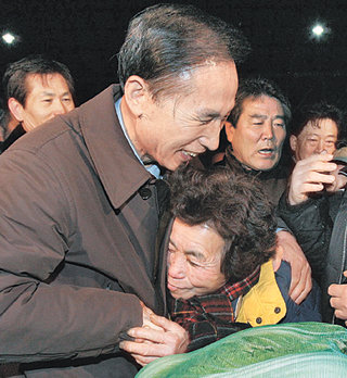 설 앞두고 가락시장 찾아 이명박 전 서울시장이 14일 서울 송파구 가락동 농수산물시장을 방문해 한 상인과 포옹하고 있다. 이 전 시장은 시장 내 상점을 둘러본 뒤 상인연합회 대표들과 대화를 나눴다. 김재명  기자