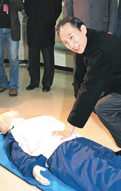 인공호흡은 이렇게… 이명박 전 서울시장이 16일 서울 마포소방서를 방문해 소방대원들을 격려한 뒤 사람 모양의 장비를 이용해 인공호흡을 시연하고 있다. 김동주  기자