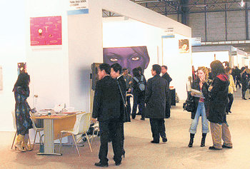 스페인 마드리드의 이페마 전시관에 설치된 한국관 중 박영덕 화랑과 박여숙 화랑의 부스를 컬렉터들이 둘러보고 있다. 뒤 얼굴 그림은 강형구 씨의 ‘신화’. 마드리드=허 엽  기자