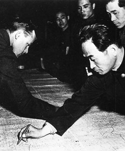 1951년 11월 판문점에서 휴전협정에 착수한 유엔군과 북한군 장교가 새 휴전선 설정을 논의하기 전 지도에 기존 38선을 긋고 있다. 국제요소와 국내요소가 복합된 분단의 중층적 성격을 잘 보여 주는 사진이다. 동아일보 자료 사진