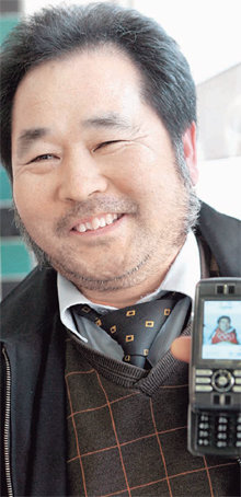 한국 입양아 출신 미국 스키스타 토비 도슨(작은 사진)의 아버지로 밝혀진 김재수 씨가 자신의 휴대전화에 저장된 토비 도슨의 사진을 보여 주고 있다. 부산=최재호 기자