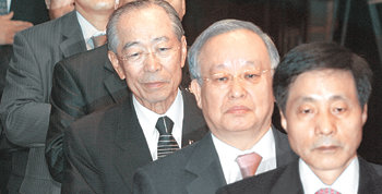 전국경제인연합회는 27일 서울 여의도 전경련회관에서 총회를 열고 차기 회장 선출 문제를 논의했지만 결론을 내리지 못했다. 참석자들이 국기에 대한 경례를 하고 있다. 오른쪽부터 장지종 중소기업중앙회 부회장, 손경식 대한상공회의소 회장, 강신호 전경련 회장. 신원건 기자 laputa@donga.com