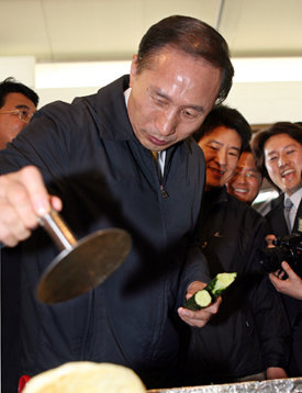 호떡 만들고이명박 전 서울시장이 2일 제주를 방문해 민속5일장터를 둘러보다 호떡가게에서 호떡을 만들어 보고 있다. 제주=연합뉴스