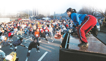 풀코스 완주를 위해서는 기록 단축보다 즐겁게 달린다는 마음가짐을 갖는 게 더 중요하다. 대회 열흘을 앞두고는 훈련량 조절과 식이요법을 병행하는 게 좋다. 사진은 출발 전 스트레칭으로 몸을 풀고 있는 모습. 동아일보 자료 사진