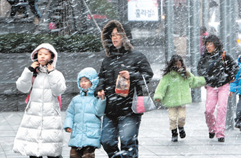 7일 오후 4시 반경부터 서울시내에 갑자기 소낙눈이 내리자 아이들이 추위에 몸을 움츠리면서도 눈을 반기고 있다. 아이들의 어머니는 자녀가 감기에 걸릴까봐 발길을 재촉하고 있다. 기상청은 8일에도 서해안 일대에 눈이 내리겠다고 예보했다. 홍진환 기자