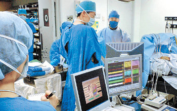 서울대병원 신경외과 백선하 교수(오른쪽)가 5개의 미세전극장치를 이용해 파킨슨병 환자의 뇌수술을 집도하는 모습을 기자(왼쪽)가 지켜보고 있다.