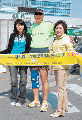13일 오후 2시 경기 수원시청 앞 목표지점에 골인한 장애인 마라토너 박종암 씨(가운데)와 나혜진 씨(왼쪽), 나 씨의 어머니 이점자 씨가 기념촬영을 하고 있다. 사진 제공 박종암 씨