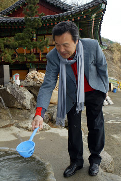 낙산사에서 손학규 전 경기지사가 16일 강원 양양군 낙산사 음수대에서 물을 뜨고 있다. 손 전 지사는 이날 낙산사를 떠난 뒤 외부와 연락을 끊었다. 양양=연합뉴스