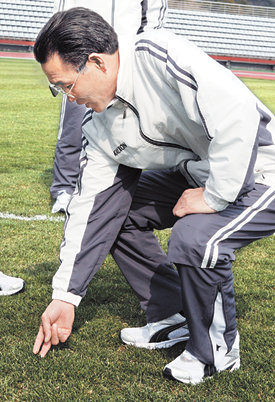 “남쪽 잔디는 어떤가…”17세 이하 북한 청소년축구대표팀의 이찬명 단장이 20일 훈련 장소인 제주 서귀포시 강창학종합경기장에 들러 잔디 상태를 살펴보고 있다. 이 단장은 1966년 잉글랜드 월드컵에서 북한이 ‘8강 신화’를 이뤘을 때 주전 골키퍼로 활약했다. 서귀포=연합뉴스