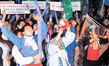 “이렇게 기쁠 수가” 27일 밤 케냐 몸바사에서 열린 국제육상경기연맹 집행이사회에서 2011년 세계육상선수권대회 개최지가 대구로 확정되자 대구 중구 동인동 국채보상운동기념공원에 모여 결과를 기다리던 시민들이 막대풍선을 두드리고 꽹과리를 치며 기쁨의 환호성을 터뜨리고 있다. 대구=박영대 기자