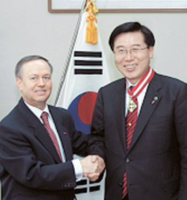 박철 한국외국어대 총장(오른쪽)이 30일 발레리우 아르테니 주한 루마니아대사를 통해 교육부문 루마니아 국가 최고 훈장(코멘다도르)을 전달받은 뒤 악수하고 있다. 사진 제공 한국외국어대