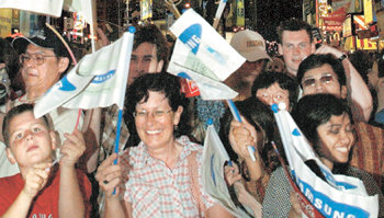 아테네 올림픽의 삼성전자 2004년 아테네 올림픽 공식 파트너 삼성전자는 전 세계를 돌며 성화 봉송 행사를 열었다. 미국 뉴욕 시민들이 타임스스퀘어에서 삼성 로고가 새겨진 깃발을 흔들며 성화 봉송을 지켜보고 있다. 사진 제공 삼성전자