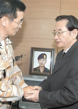 아프가니스탄에서 폭탄 테러로 숨진 윤장호 하사의 아버지 윤희철 씨(오른쪽)가 3일 다산부대장인 이인희 대령의 위로를 받고 있다. 신원건 기자