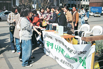 식목일을 맞아 몽골 나무 심기 운동인 ‘솔롱거스 회원 모집 캠페인’을 벌인 시민정보미디어센터 관계자들이 시민들에게 황사 마스크를 나누어 주고 있다. 사진 제공 시민정보미디어센터