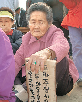 7일 오후 미군기지 이전 예정지인 경기 평택시 대추리 대추분교에서 열린 ‘고향 땅 회복 기원’ 행사에서 한 할머니가 소원을 써 넣은 향나무판을 앞에 두고 착잡한 표정을 짓고 있다. 평택=연합뉴스