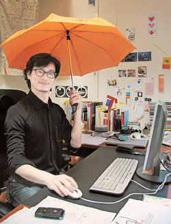 싸이월드 메인 페이지와 브랜드이미지 개편 작업을 총괄한 SK커뮤니케이션즈 한명수 이사가 사무실에서 싸이월드의 주색인 주황색 우산을 들고 있다. 사진 제공 SK커뮤니케이션즈