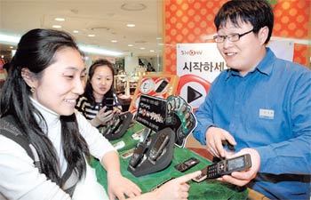3세대 이동통신 서비스가 시작된 지난달 1일, 한 고객이 매장에서 화상통화가 가능한 휴대전화를 고르고 있다. 사진 제공 KTF