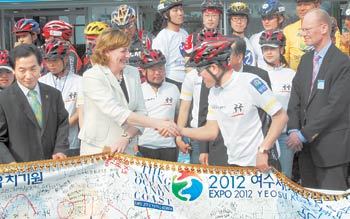 여수 개최 지지 서명부 전달 2012 세계박람회 개최 후보지인 전남 여수시에서 이틀째 실사를 벌이고 있는 세계박람회기구(BIE) 실사단의 카르맹 실뱅 단장(앞줄 왼쪽에서 두 번째)이 ‘2012 트윈 전국 사이클 투어단’으로부터 여수 개최 지지 서명부를 전달받고 있다. 사이클 투어단은 전국 10개 도시를 돌며 서명운동을 벌였다. 여수=박영철 기자