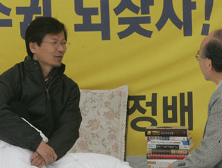 한미 자유무역협정(FTA) 체결을 반대하며 서울 여의도 국회의사당 본청 출입문 앞에서 단식 농성 중인 천정배 의원(왼쪽)이 15일 방문객과 대화를 나누고 있다. 연합뉴스