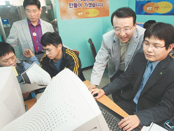 남중수 KT 사장(오른쪽에서 두 번째)이 장애인을 위한 ‘인터넷 홈페이지 만들기’ 수업에 참가해 교육 내용을 살펴보고 있다. 남 사장은 “정보기술(IT) 지식 기부를 통해 지속적으로 성장하는 사회를 만들고 싶다”고 말했다. 박영대  기자