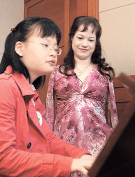 선천성 다운증후군을 앓는 임유진 씨(19)가 자신에게 피아니스트의 꿈을 갖게 해 준 복음성가 가수 레나 마리아 씨(39·오른쪽)를 22일 서울 강동구 명일동 명성교회에서 만나 피아노를 연주해 보이고 있다. 홍진환 기자