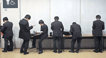 다시 활황을 맞은 일본 기업들이 요즘 대학 졸업생들을 모셔 가기 위해 치열하게 경쟁하고 있다. 올해 초 도쿄에서 열린 한 취업설명회에서 대졸자들이 면담을 기다리며 자료를 살펴보고 있다. 동아일보 자료 사진