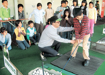 충북 진천군 구정초등학교 학생들이 티칭프로에게서 어드레스 자세를 교정 받고 있다. 이 학교 4, 5, 6학년생 전원은 일주일에 4시간씩 골프 교육을 받고 있다. 진천=장기우 기자