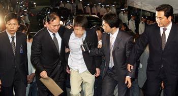 아들도 출두 30일 오후 11시 5분 김승연 한화그룹 회장의 둘째 아들 김모 씨(가운데)가 경찰 조사를 받기 위해 서울 남대문경찰서에 들어서면서 취재진의 질문을 받고 있다. 전영한  기자