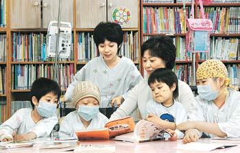 서울 서대문구 신촌동 세브란스병원의 어린이병원학교에서 어린이 환자들이 자원봉사자와 함께 책을 읽고 있다. 홍진환  기자