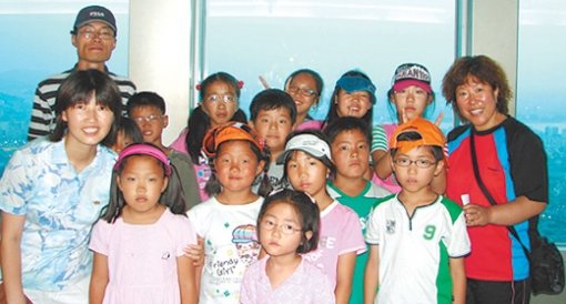이인순(왼쪽 뒤) 이은정(왼쪽 앞) 씨 부부와 이작분교 아이들이 지난해 한 극단의 초청을 받아 서울 남산 N서울타워 전망대에 올랐다. 사진 제공 이작분교