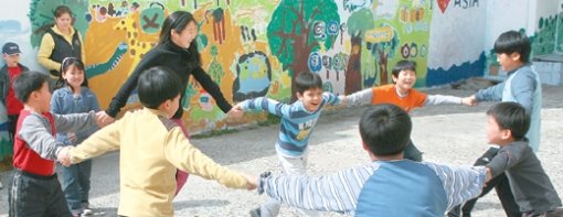 부산 남구 문현동에 있는 아시아공동체학교 어린이들이 자신들이 그린 벽화 앞에서 놀고 있다. 부산=최재호  기자