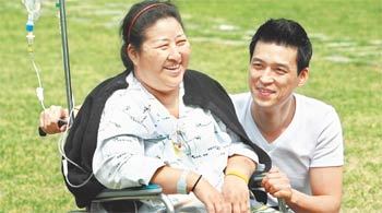 8일 오전 서울 신촌세브란스병원에서 암으로 투병 중인 송영혜 씨(왼쪽)가 아들과 함께 산책을 나와 활짝 웃고 있다. 죽기 전까지 사진을 절대로 안 찍겠다던 송 씨였지만 아들의 설득에 기꺼이 사진 촬영에 응했다. 젊은 시절 영화배우 최은희 씨를 닮았다는 이야기를 많이 들었던 송 씨는 몸이 많이 부어 있었지만 웃음과 여유를 잃지 않았다. 김미옥 기자