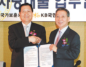 강정원 국민은행장(오른쪽)과 김정복 국가보훈처장이 25일 서울 영등포구 여의도동 63빌딩에서 ‘국가유공자 등에 대한 대부업무 위탁 협약’을 체결한 뒤 악수하고 있다. 사진 제공 국민은행