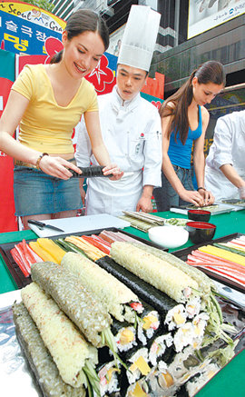 서울의 명소 중에서 가장 많은 외국인 관광객이 찾은 곳은 중구 명동이다. 명동 거리에서 열린 ‘김밥만들기 체험’ 이벤트에서 외국인 관광객들이 직접 김밥을 만들어 보고 있다. 동아일보 자료사진