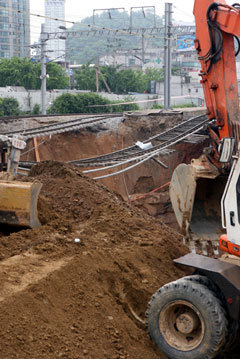 4일 오전 경의선 철도 가좌역 인근 공사구간 붕괴현장에 대한 복구 공사가 진행되고 있다. 철도청은 이 날 오전 붕괴지역에 흙을 메우는 작업을 시작해 6일 오후까지는 철도가 재개되도록 하겠다고 밝혔다. 변영욱기자 cut@donga.com