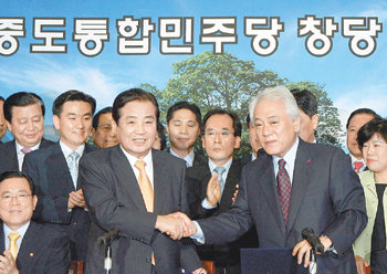 박상천 민주당 대표(앞줄 왼쪽), 김한길 중도개혁통합신당 대표가 4일 국회에서 합당 선언식을 한 뒤 악수하고 있다. 양당은 당명을 ‘중도통합민주당(약칭 통합민주당)’으로 정했다. 이종승  기자