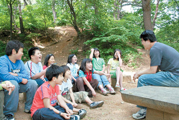 학생도 교사도 나무 그늘 아래에 들면 모두 ‘자연의 아이들’이다. 경기 광주시 남한산초등학교 5학년 학생들이 학교 뒷산 숲 속에서 나무 관찰을 하기에 앞서 담임인 김우석 교사와 수업 내용에 대해 이야기를 나누며 웃음을 터뜨리고 있다. 광주=남경현 기자