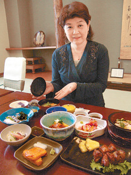 사쓰마요리 향토식당인 ‘구마소테이’(가고시마 시내)의 상차림과 지배인 구로카와 마키코 씨.