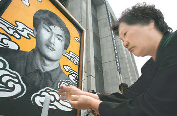 1987년 6월 경찰이 쏜 최루탄에 맞아 숨진 이한열 씨 20주기 추모제가 서울 연세대 중앙도서관 앞에서 열렸다. 이 씨의 어머니 배은심 씨가 2004년 훼손돼 이날 새로 완성된 이 씨의 영정 앞에서 분향하고 있다. 신원건  기자