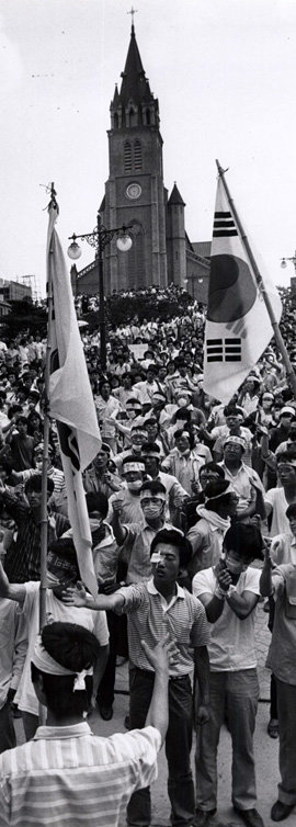 1987년 6월 민주항쟁의 진원지였던 서울 중구 명동성당. 당시 시위대가 성당 입구 광장에서 태극기를 들고 ‘호헌철폐, 독재타도’ 구호를 외치고 있다. 동아일보 자료 사진