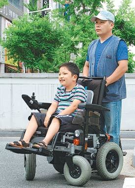 휠체어에 몸을 맡긴 재국 군과 아버지 배종훈 씨가 13일부터 25일 동안의 ‘근육병 환아를 위한 희망의 국토 종단’을 앞두고 완주 의지를 다지고 있다. 사진 제공 메이크어위시재단