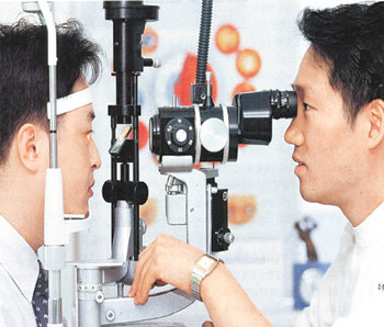 한 안과 의사가 눈 검사 기기를 통해 환자의 눈 상태를 확인하고 있다. 동아일보 자료 사진