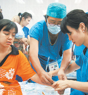 서울대 의대 민경원(성형외과·가운데) 교수와 분당서울대병원 배한주 간호사(오른쪽)가 화상 흉터로 수술을 받은 환자에게 항생제 주사를 놓고 있다. 타슈켄트=홍수영  기자