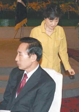 박근혜 전 한나라당 대표가 26일 서울 종로구 한 음식점에서 열린 당 국책자문위원회 출범식에서 연설을 한 뒤 이명박 전 서울시장 뒤를 돌아 자신의 자리로 가고 있다. 이종승 기자