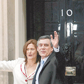 브라운 들어오고27일 취임한 고든 브라운 영국 신임 총리가 부인 사라 씨와 함께 런던 다우닝가 10번지 총리 관저 입구에서 손을 흔들고 있다. 런던=EPA 연합뉴스