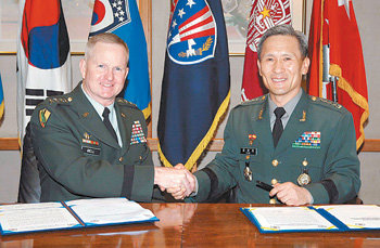 김관진 합동참모본부 의장(오른쪽)과 버웰 벨 주한미군 사령관이 28일 서울 용산 주한미군 기지에서 2012년 전시작전통제권 전환을 위한 단계별 이행계획서에 공동 서명한 뒤 악수를 하고 있다. 사진 제공 합동참모본부
