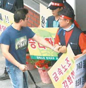 현대차 정문 통제 승강이29일 금속노조 현대차지부의 파업집회가 열린 현대자동차 울산공장 정문 앞에서 회사 밖으로 나가려는 직원(왼쪽)과 이를 막으려는 노조 간부가 승강이를 하고 있다. 울산=연합뉴스