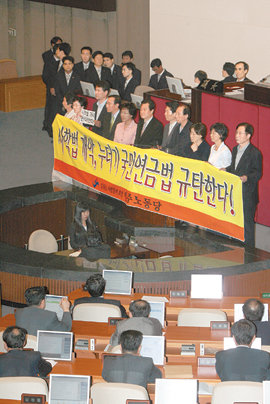 민노당 의원들 반대 농성3일 밤 민주노동당 의원들이 국회 본회의장 국회의장석 아래에서 사학법 개정안 등의 처리에 반대하는 플래카드를 들고 농성하고 있다. 그러나 국회는 임채정 국회의장의 사학법 개정안 직권 상정에 따라 법안을 통과시켰다. 김동주 기자